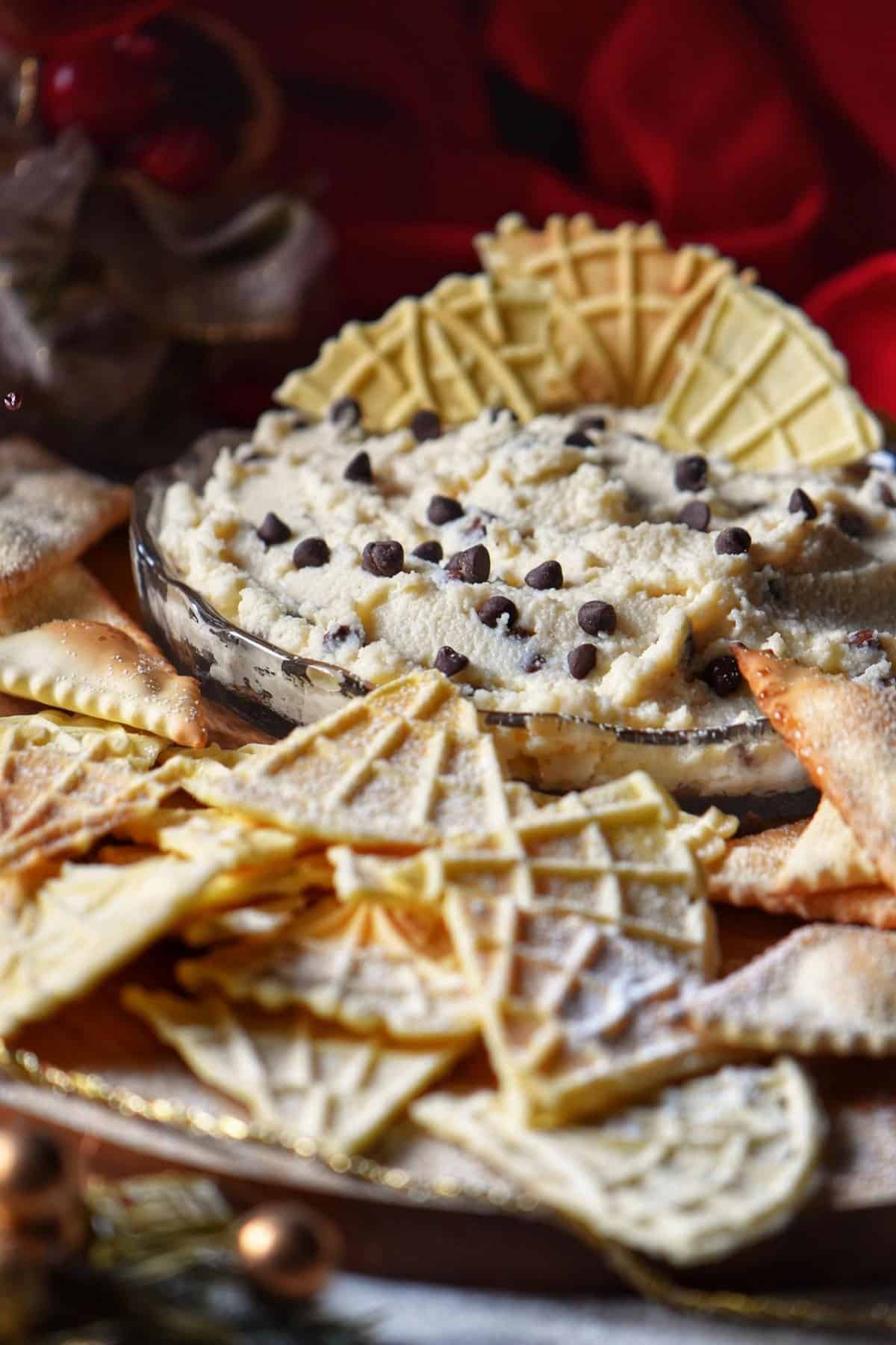 Cannoli Dip surrounded by pizzelles and air fryer Italian cookies.