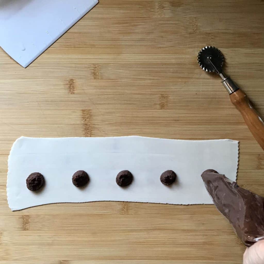 The filling is placed on the stretched out pastry dough for the chestnut cookies.