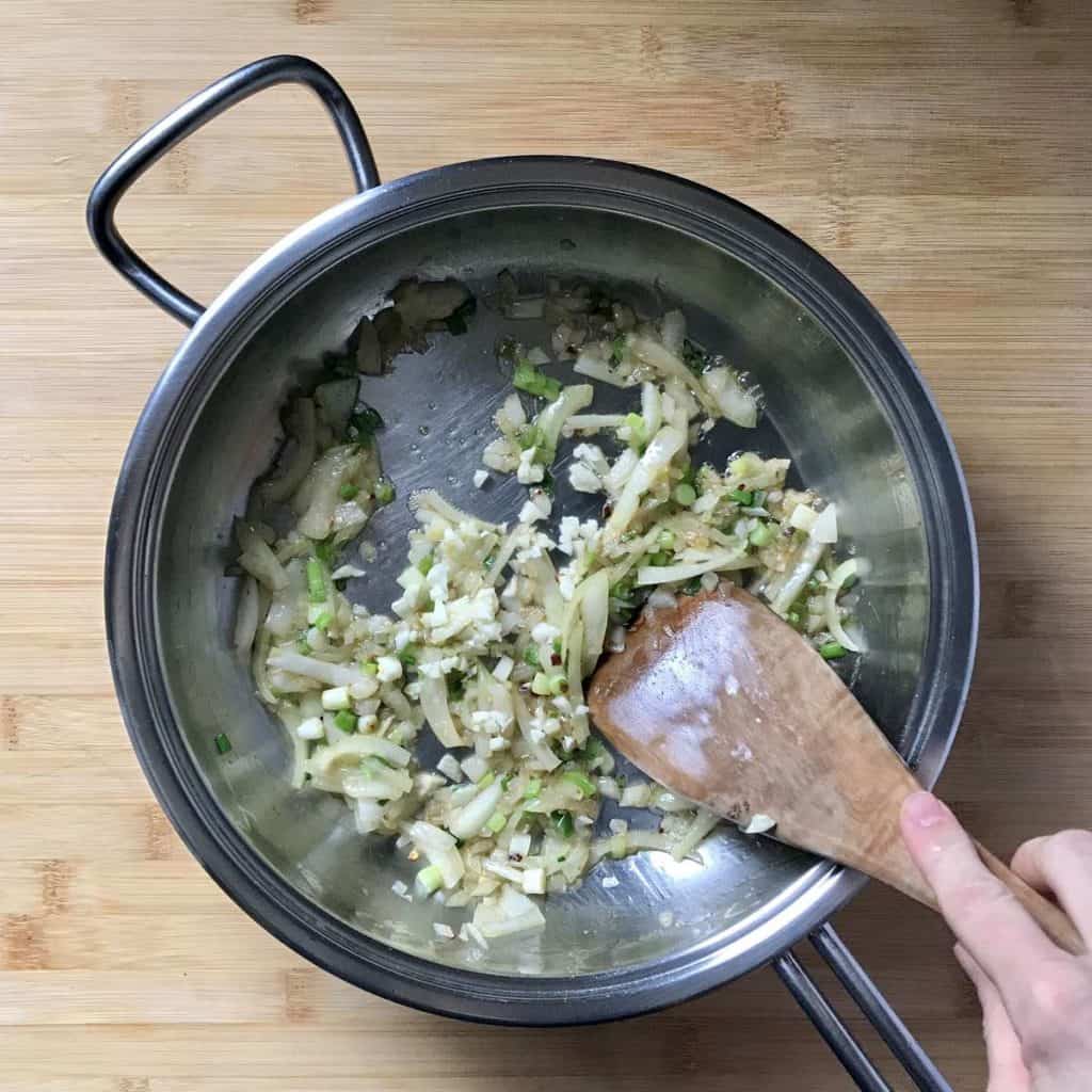 Onions, shallots and garlic sauteed in a saucepan.