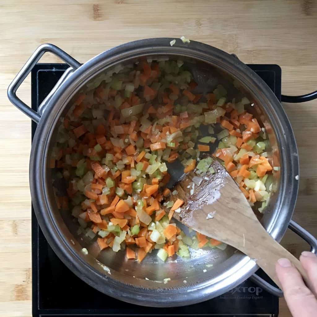 Vegetables being sauteed in a pot.
