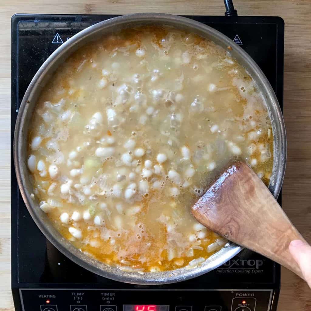 Cannellini beans simmering in a pot.