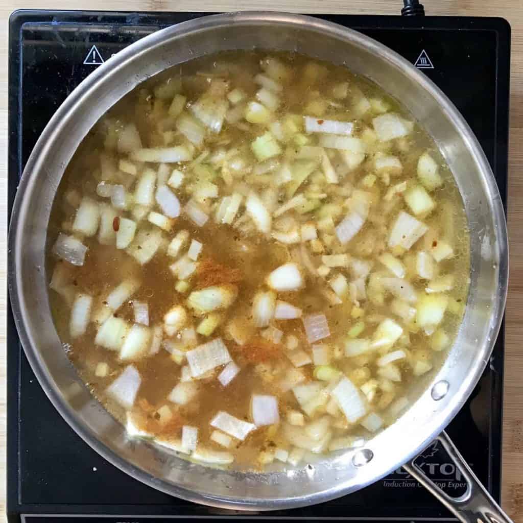 Chopped vegetables simmering in a vegetable broth.