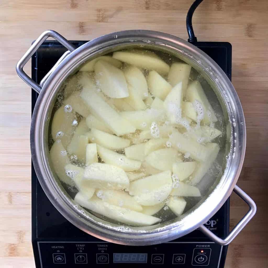 A pot of water filled with potatoes.