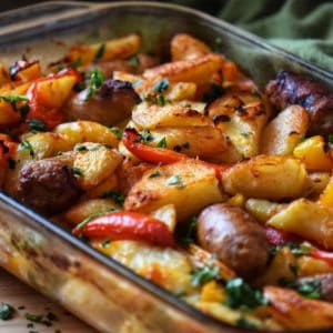 Italian Sausage, Potatoes, Peppers, and Onions in a baking dish.