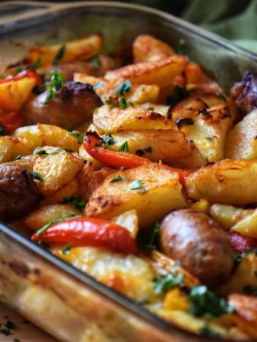 Italian Sausage, Potatoes, Peppers, and Onions in a baking dish.