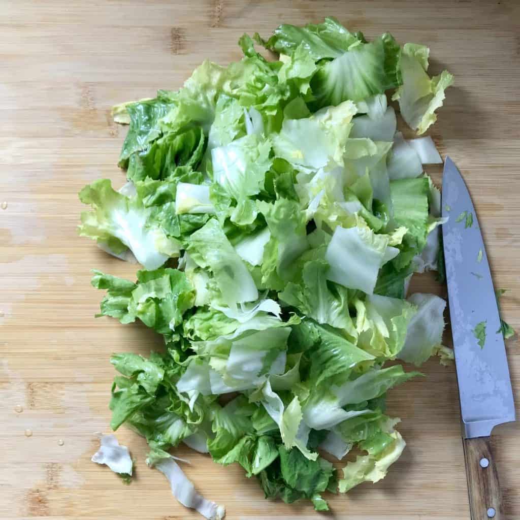 Chopped escarole on a wooden board.