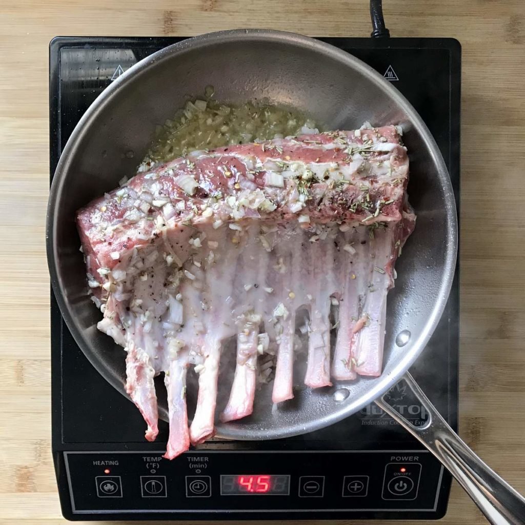 A rack of lambs being pan seared.