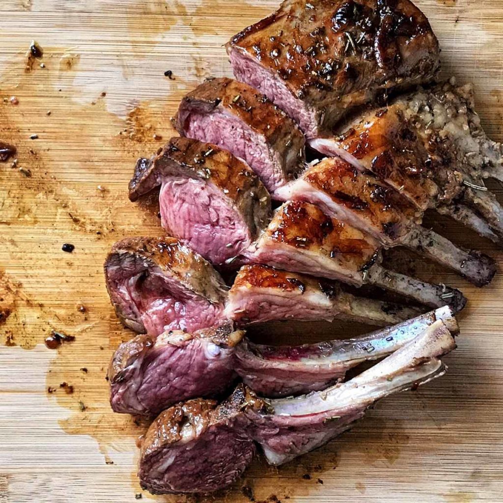A rack of lamb on a wooden board.