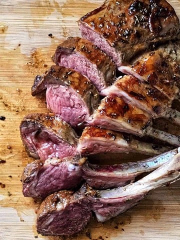 A rack of lamb on a wooden board.