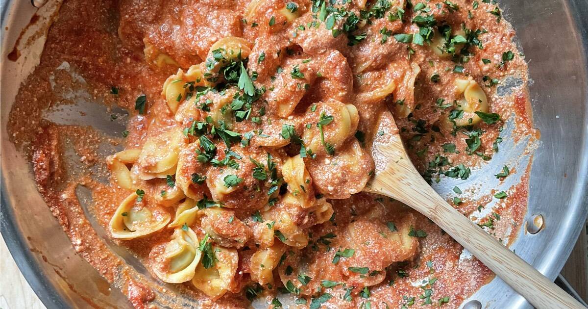 A skillet with tortellini and tomato ricotta sauce.
