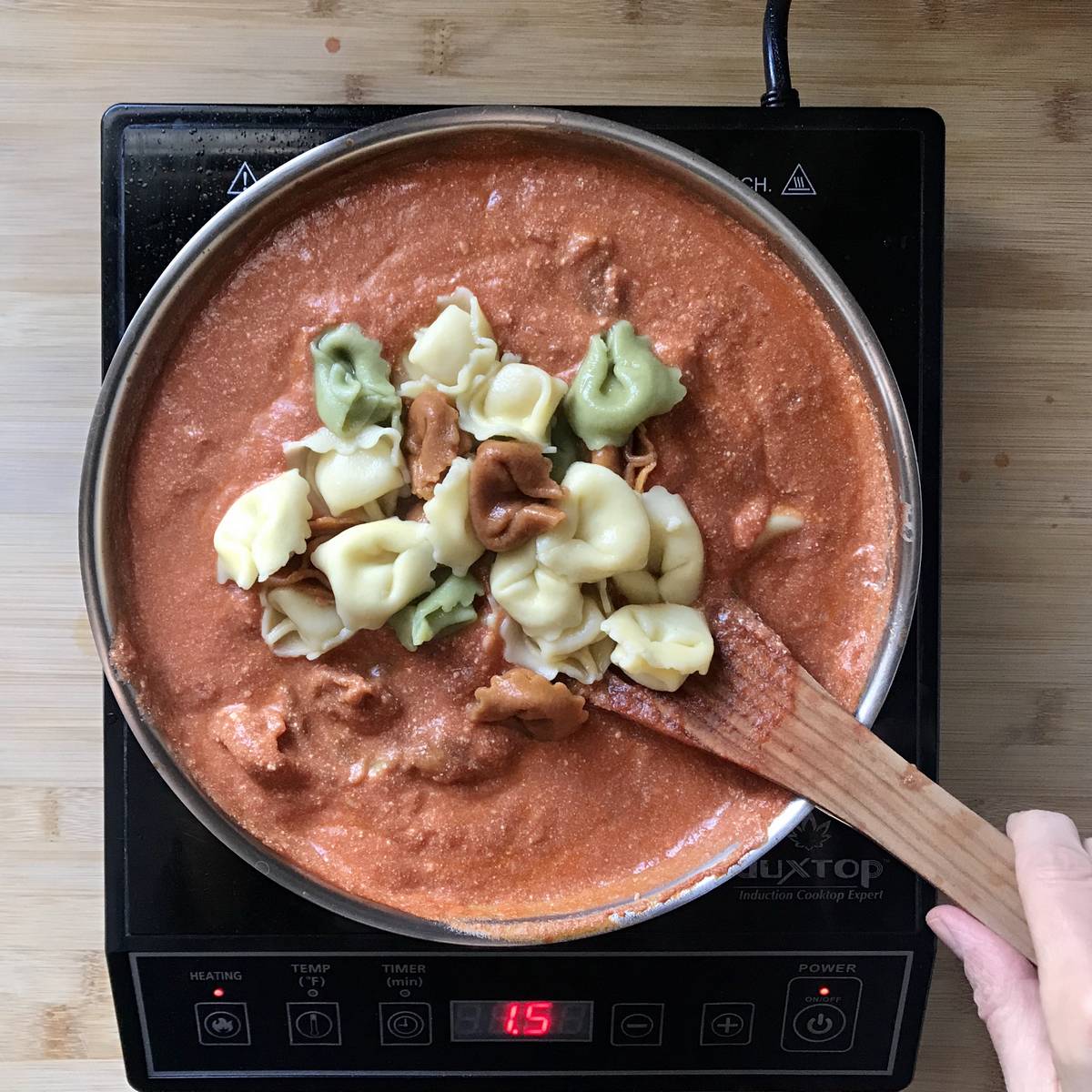 Cheese tortellini added to the pink sauce.