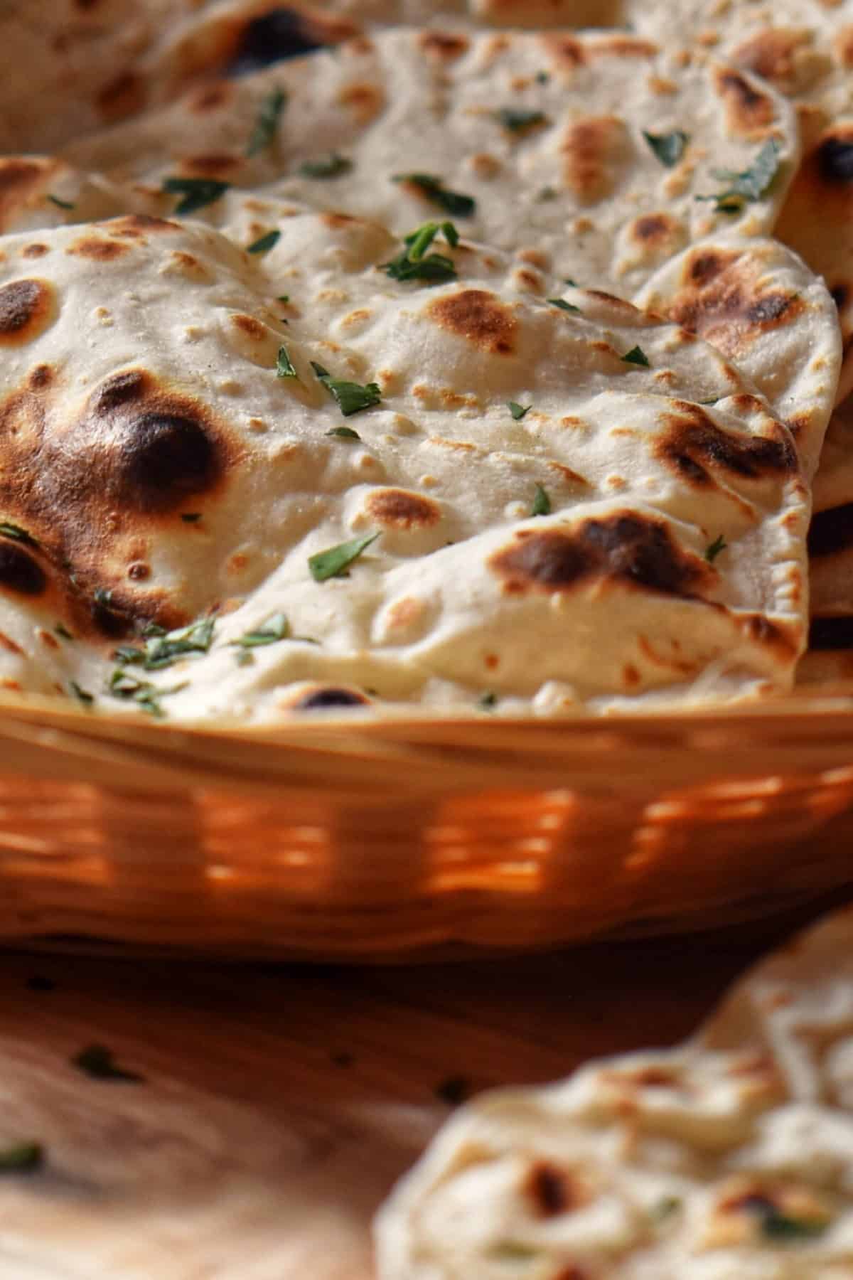 Quick flatbread garnished with parsley in a wicker basket.