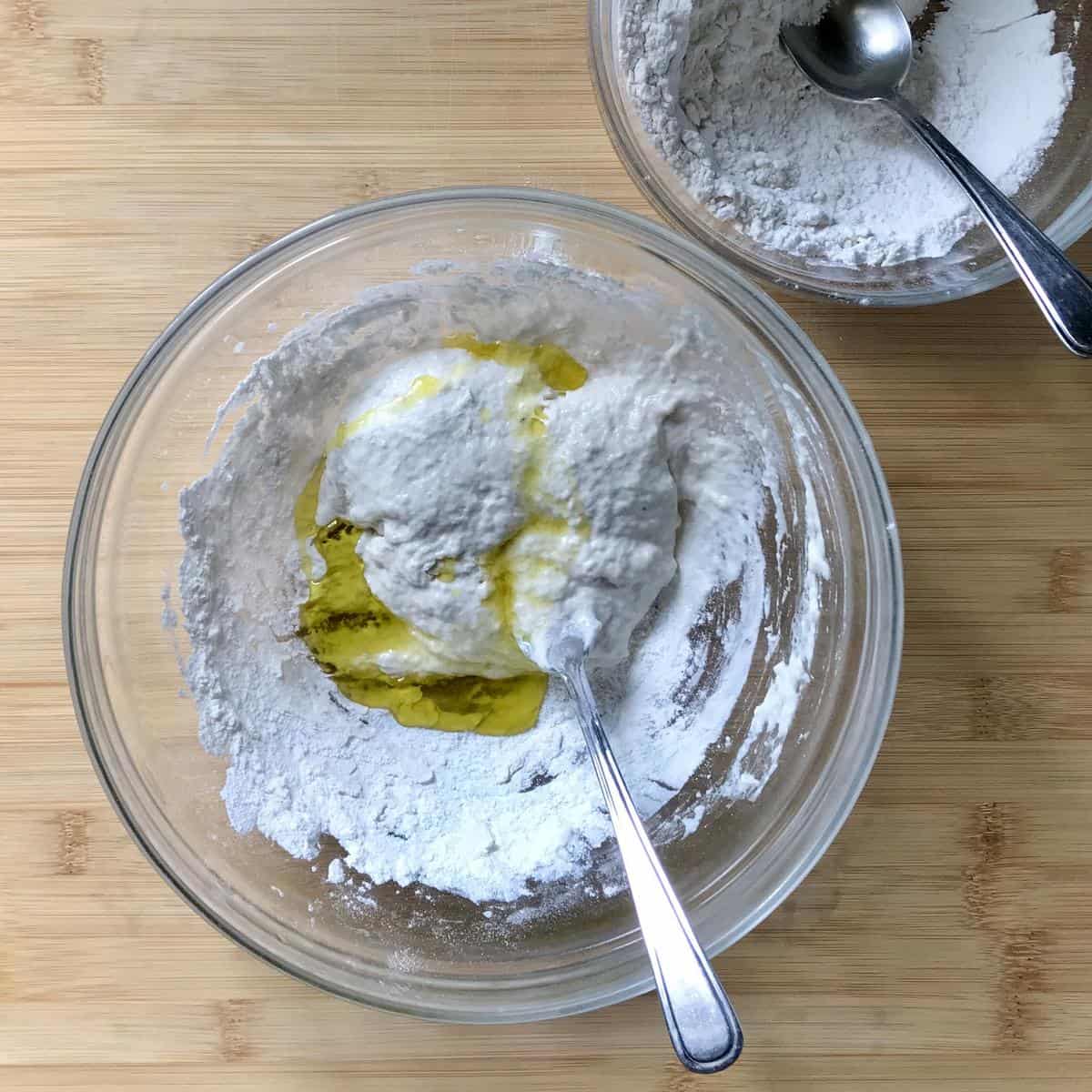 Olive oil is added to the flour mixture in the bowl.