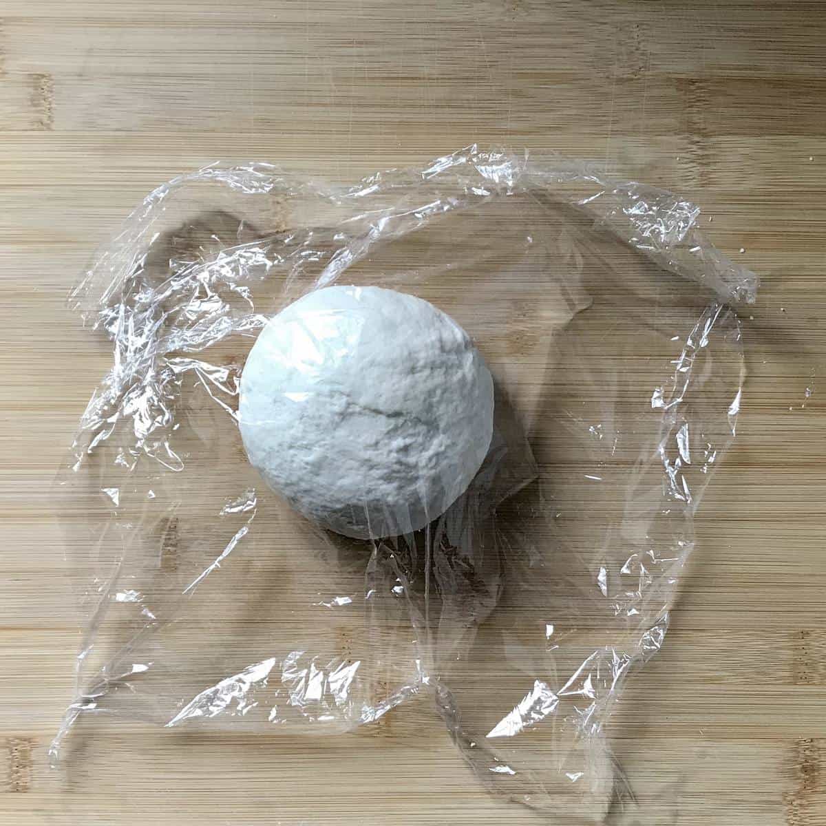 Plastic film is used to cover the ball of dough.