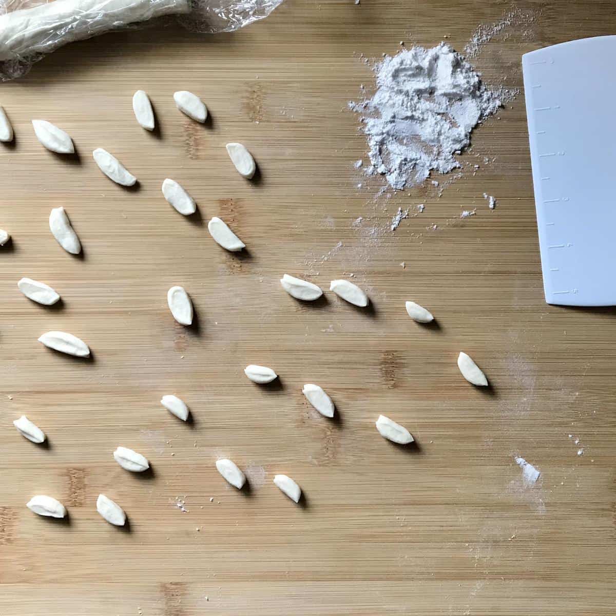 Ricotta cavatelli on a wooden board, ready to be shaped.