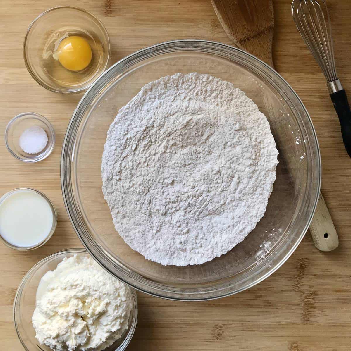 Ingredients for this homemade pasta recipe are measured and placed in bowls.