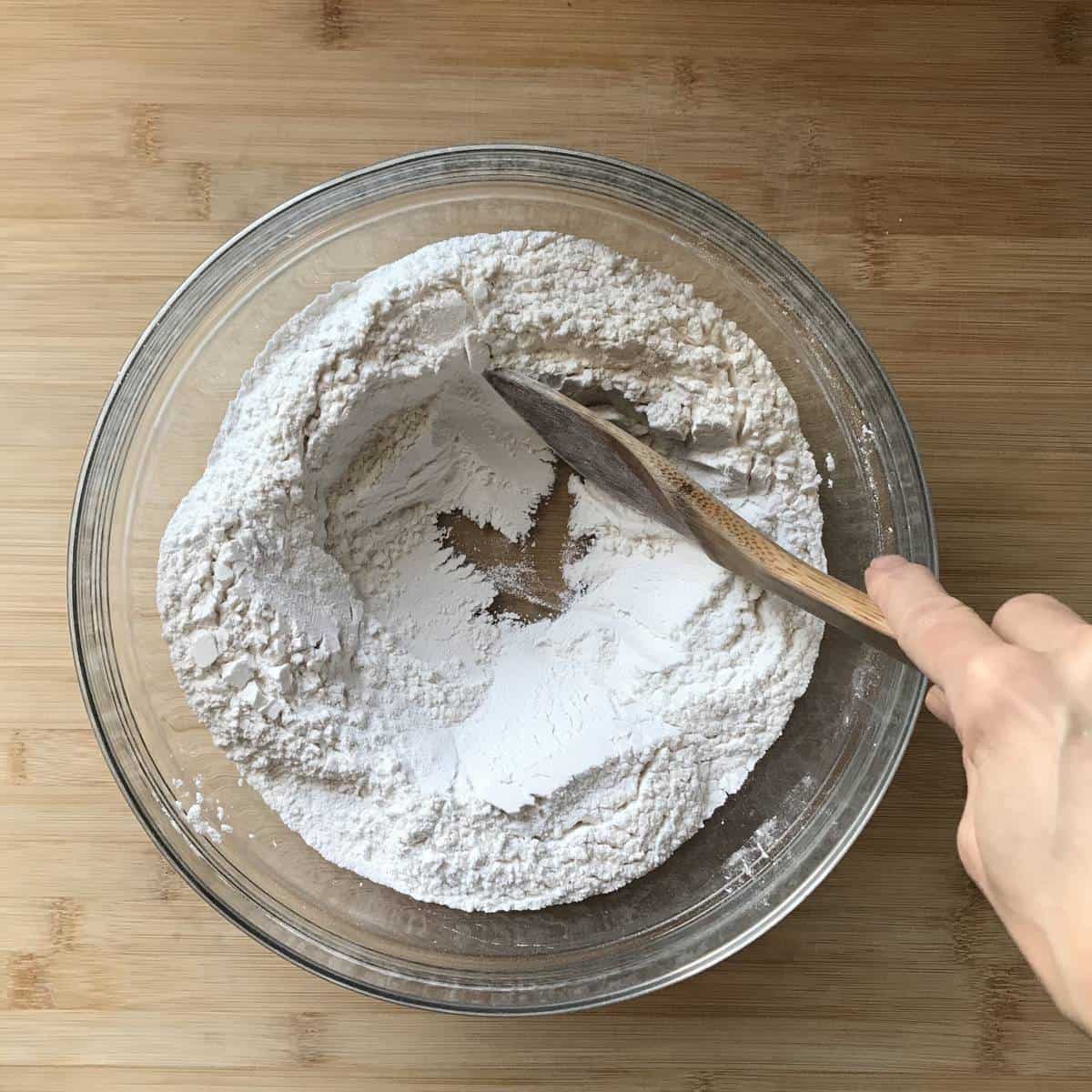 A well is created with flour that has been placed in a bowl.