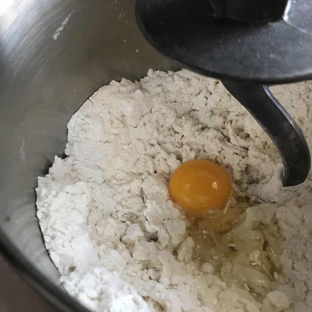 The ingredients to make ricotta cavatelli are in a bowl of a stand mixer.