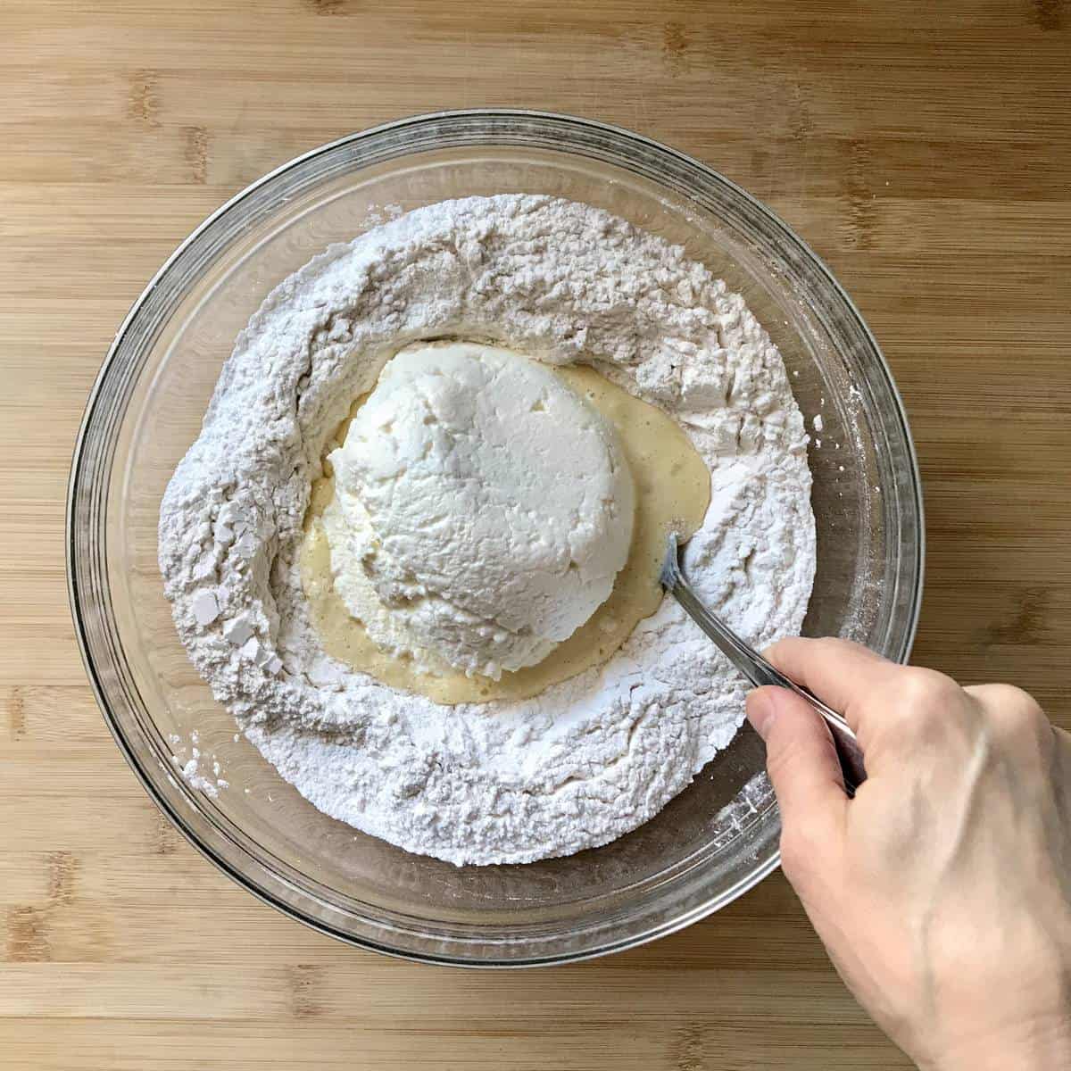 Liquid ingredients are being combined in the well of flour.