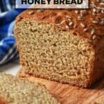 A loaf of wheat bread with honey on a wooden board.