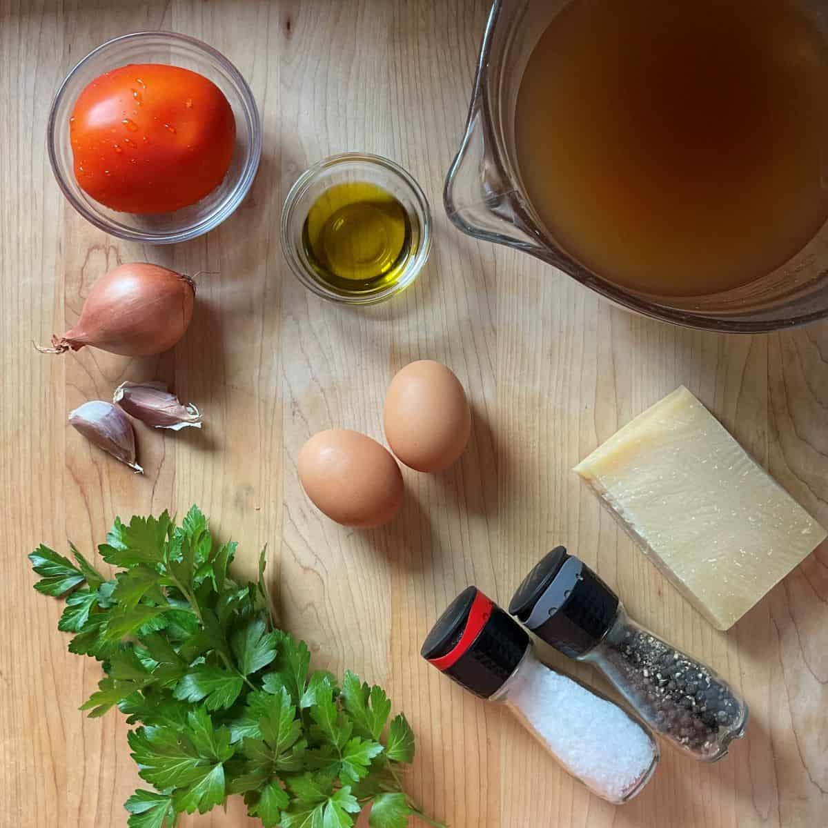 Ingredients to make Italian egg drop soup on a wooden board.