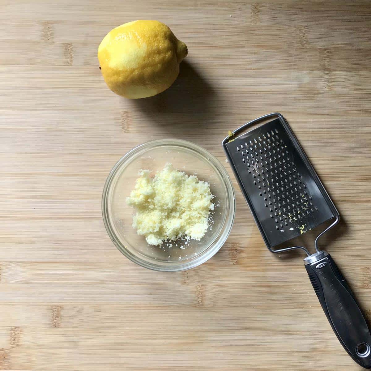 Lemon sugar in a bowl on a wooden table.