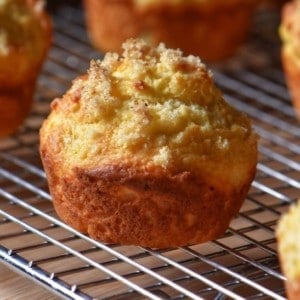 A lemon ricotta muffin set on a wire rack.