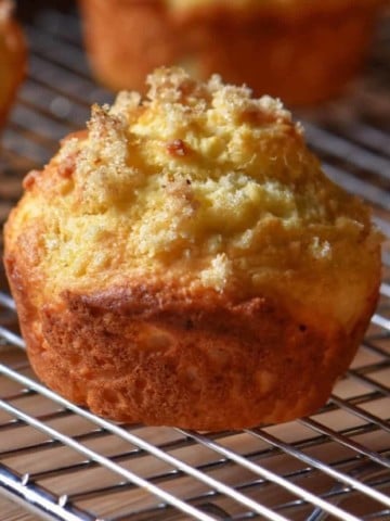 A lemon ricotta muffin set on a wire rack.