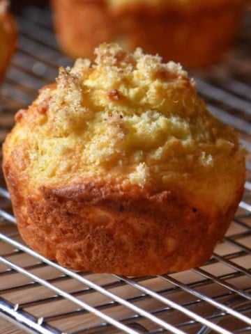 A lemon ricotta muffin set on a wire rack.