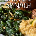 Sauteed spinach with garlic on a white dinner plate.