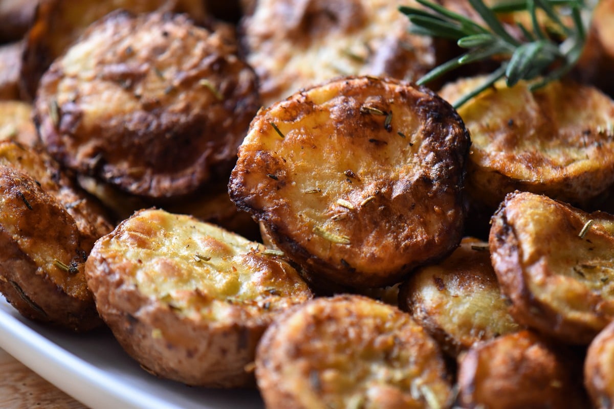 Air fryer potatoes on a white serving dish.