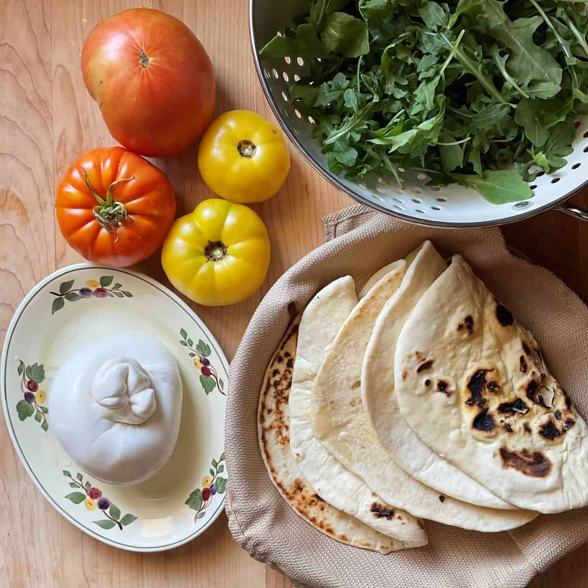 Ingredients to make a Piadina sandwich on a wooden table. 