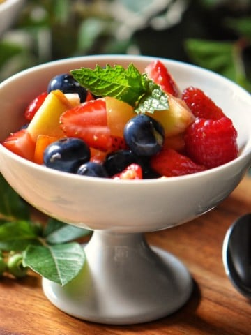 Fresh fruit salad in a white serving dish.