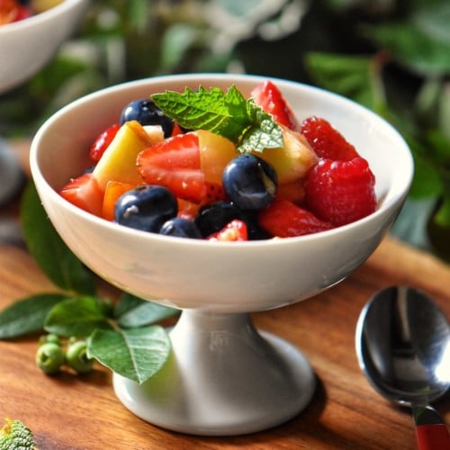 Fresh fruit salad in a white serving dish.