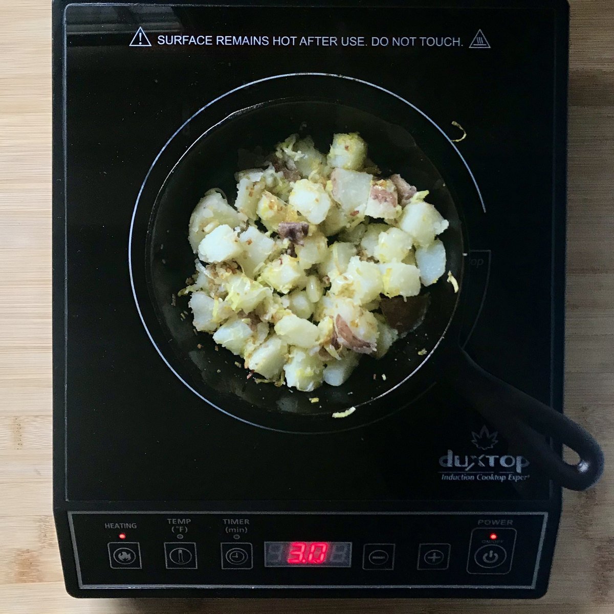 Diced potatoes in a cast iron pan.