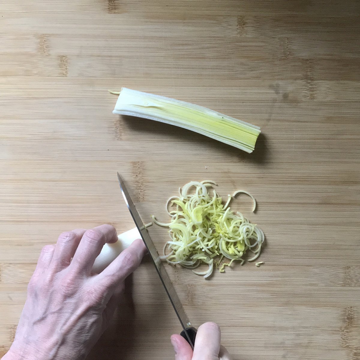 The white part of one leek in teh process of being chopped.