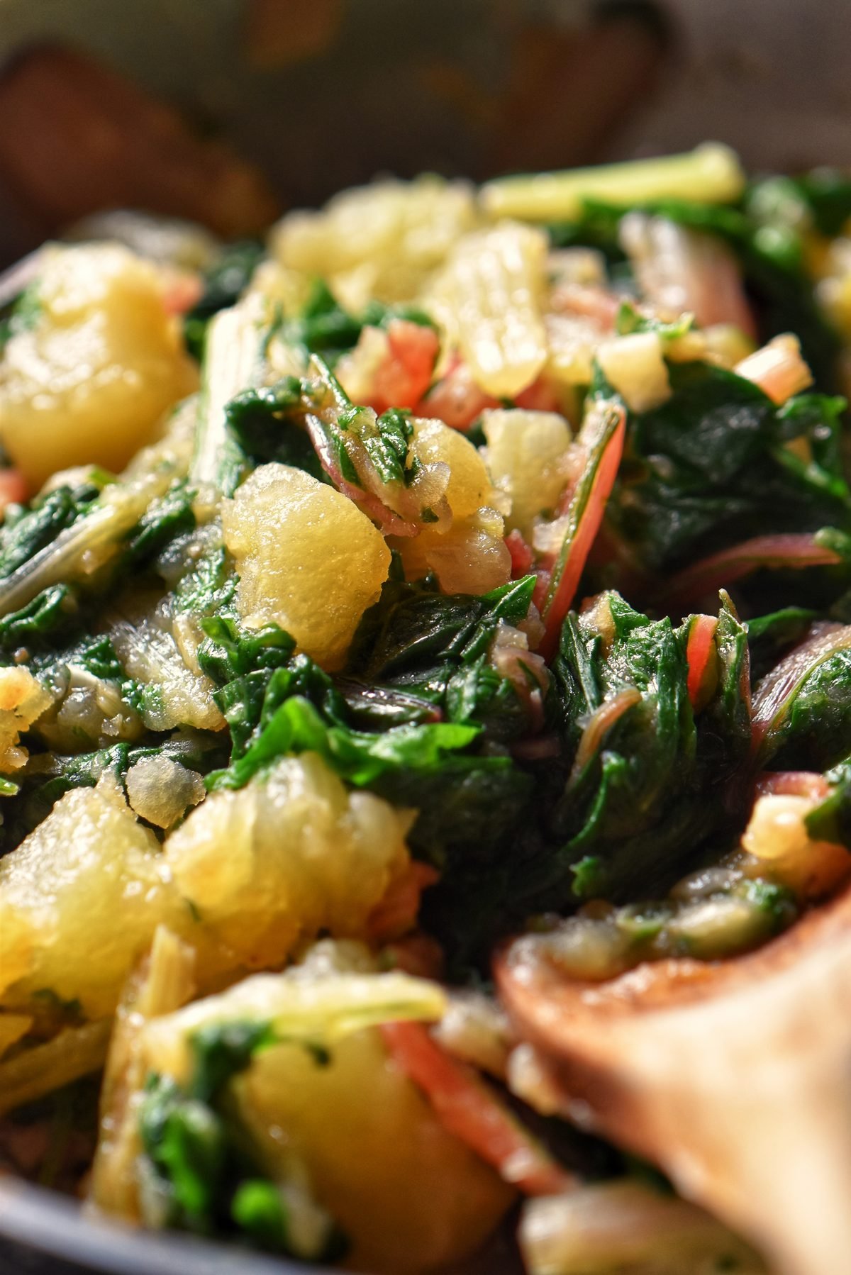 Potatoes and Swiss chard being sauteed together.