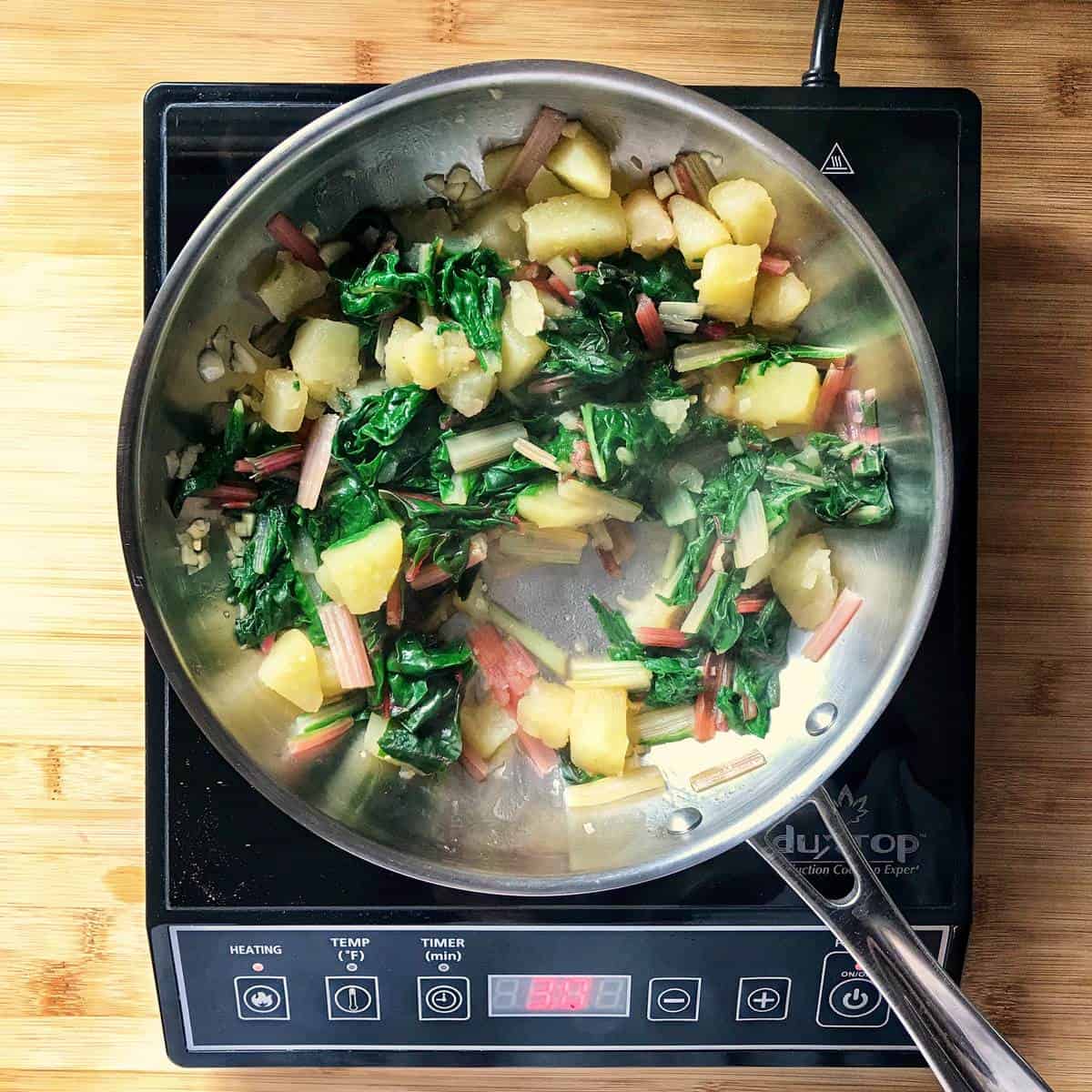 Swiss chard and potatoes in a pan.