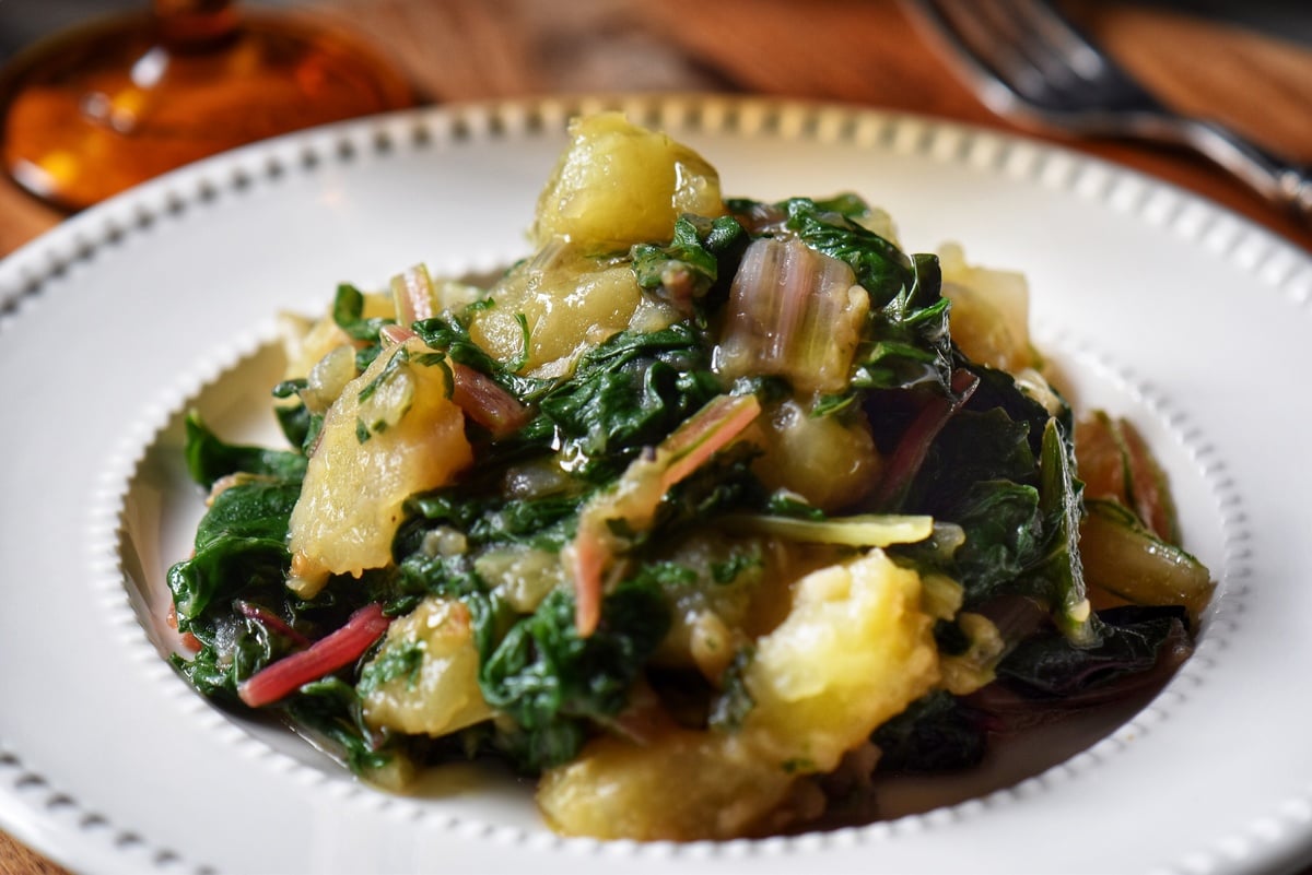 Swiss chard and potatoes in a white bowl.