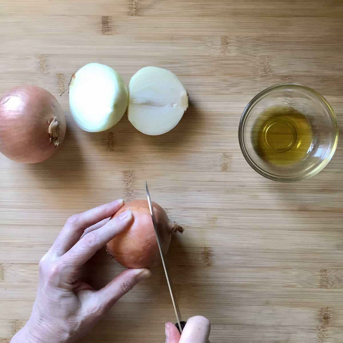 The stem is in the process of being cut off the onion.