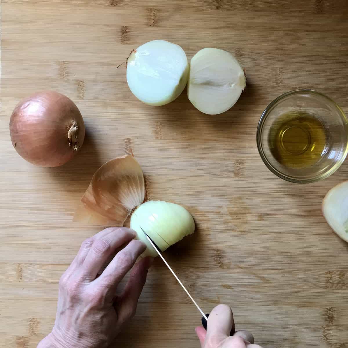 A half onion being sliced. 