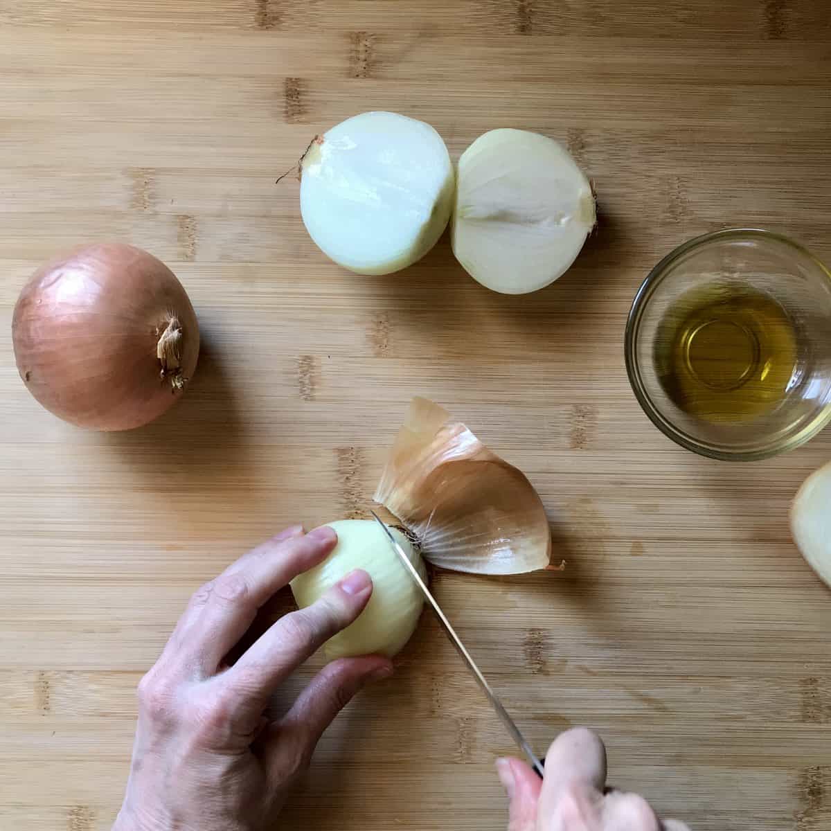 The root of the onion being sliced off.