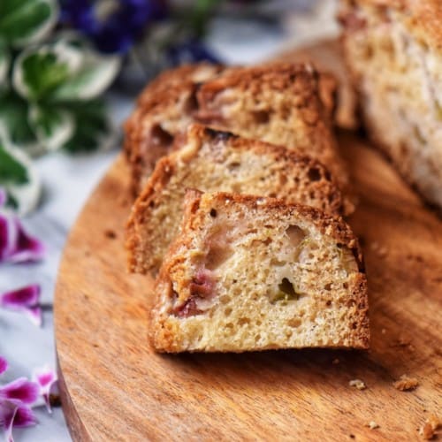 Sliced rhubarb cake on a wooden board.