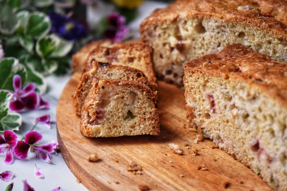 Sliced rhubarb cake on a wooden board.