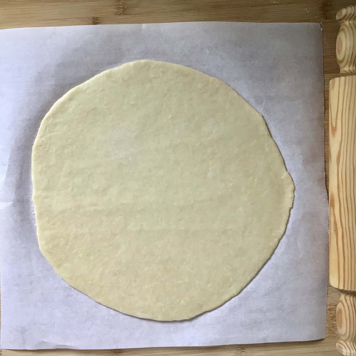 Rolled out pastry dough on parchment paper.