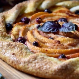 A peach crostata baked to perfection on a wooden board.