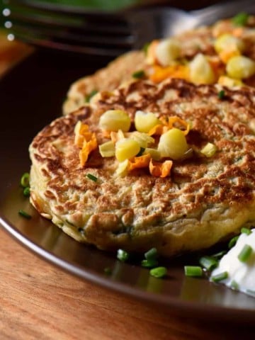 Zucchini pancakes and yogurt sauce in a dinner plate.