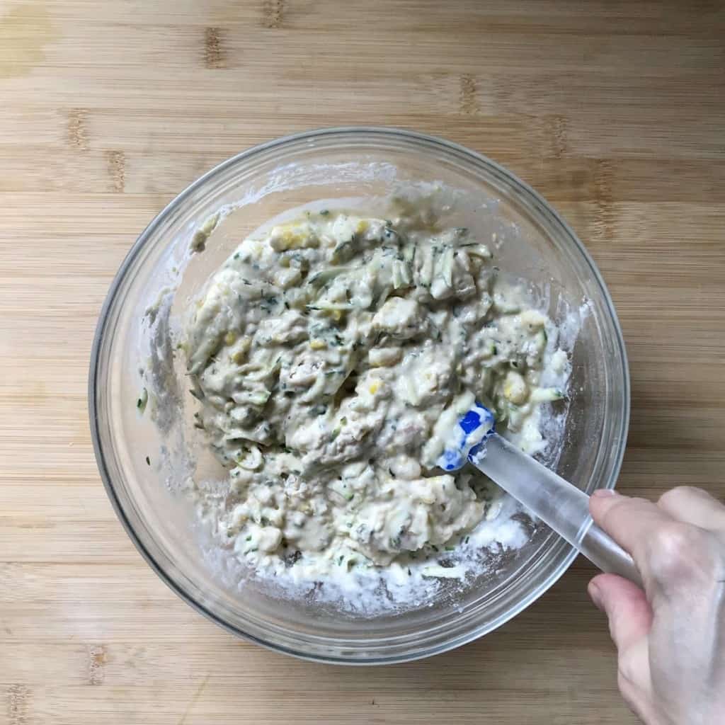 Wet and dry ingredients to make vegetable pancakes being combined in a bowl.