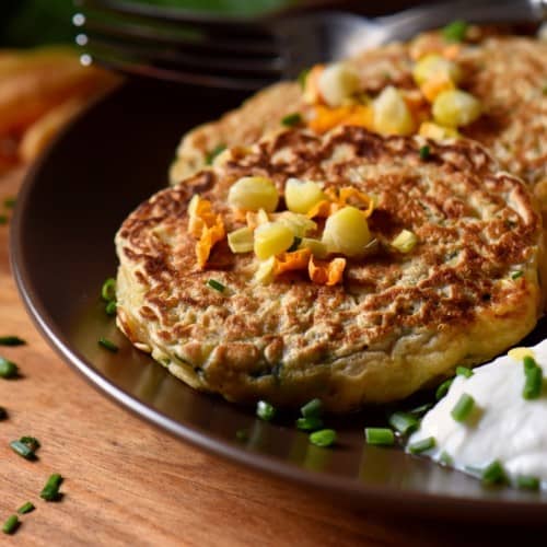 Zucchini pancakes and yogurt sauce in a dinner plate.