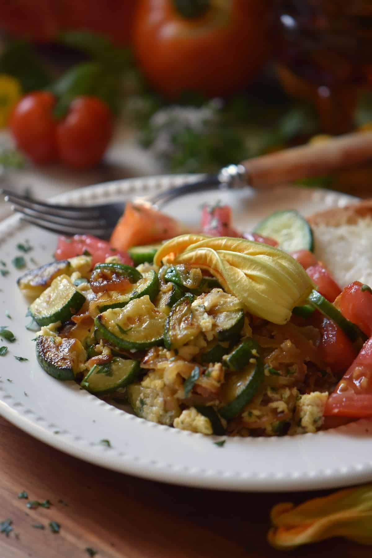 A white plate filled with sauteed zucchini and eggs. 